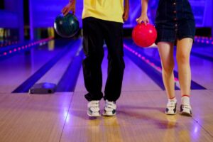 couple holding ball in bowling alley