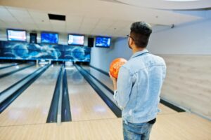 man standing at bowling alley with ball at hand