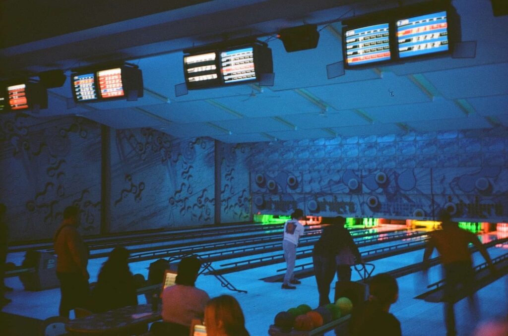 people standing around a bowling alley