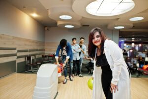 women standing in bowling alley