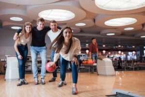 young people playing bowling in bowling alley