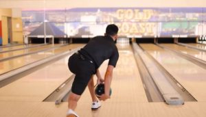 a bowler is Throwing a bowling ball